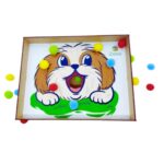 Brinquedo Cachorrinho Papa Pompons da Materiais para Brincar, mostrando uma caixa de madeira com desenho de cachorro e pompons coloridos.