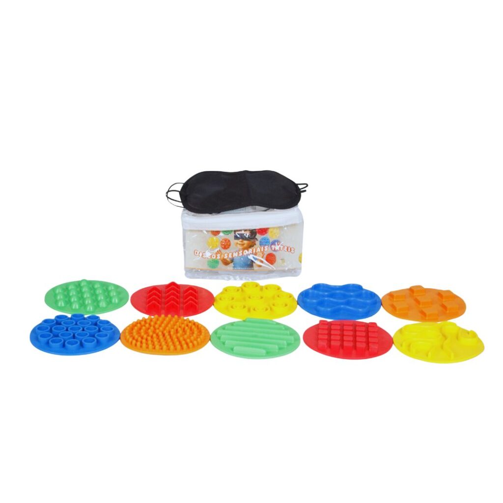 Kit de 10 discos sensoriais táteis coloridos sobre um fundo claro. Discos têm texturas variadas e estão organizados em duas fileiras, junto a um tapa-olho preto.