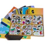 Kit Histórias para Brincar da Materiais Para Brincar, mostrando a caixa de madeira aberta com as fichas e os cenários de madeira organizados ao redor, prontos para a brincadeira.