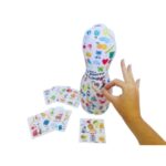 O jogo Na Ponta da Língua da Materiais Para Brincar. Uma mão de criança está dando um peteleco no João Bobo inflável. Uma das fichas do jogo, com a imagem de uma "lata", está visível ao lado.