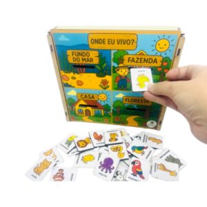 O jogo Onde Eu Vivo? da Materiais Para Brincar, mostrando a caixa de MDF com as fichas de habitats (fazenda, floresta, mar) e fichas de animais coloridas que se encaixam neles.